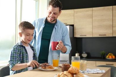 Photo of Dad and son having breakfast together in kitchen