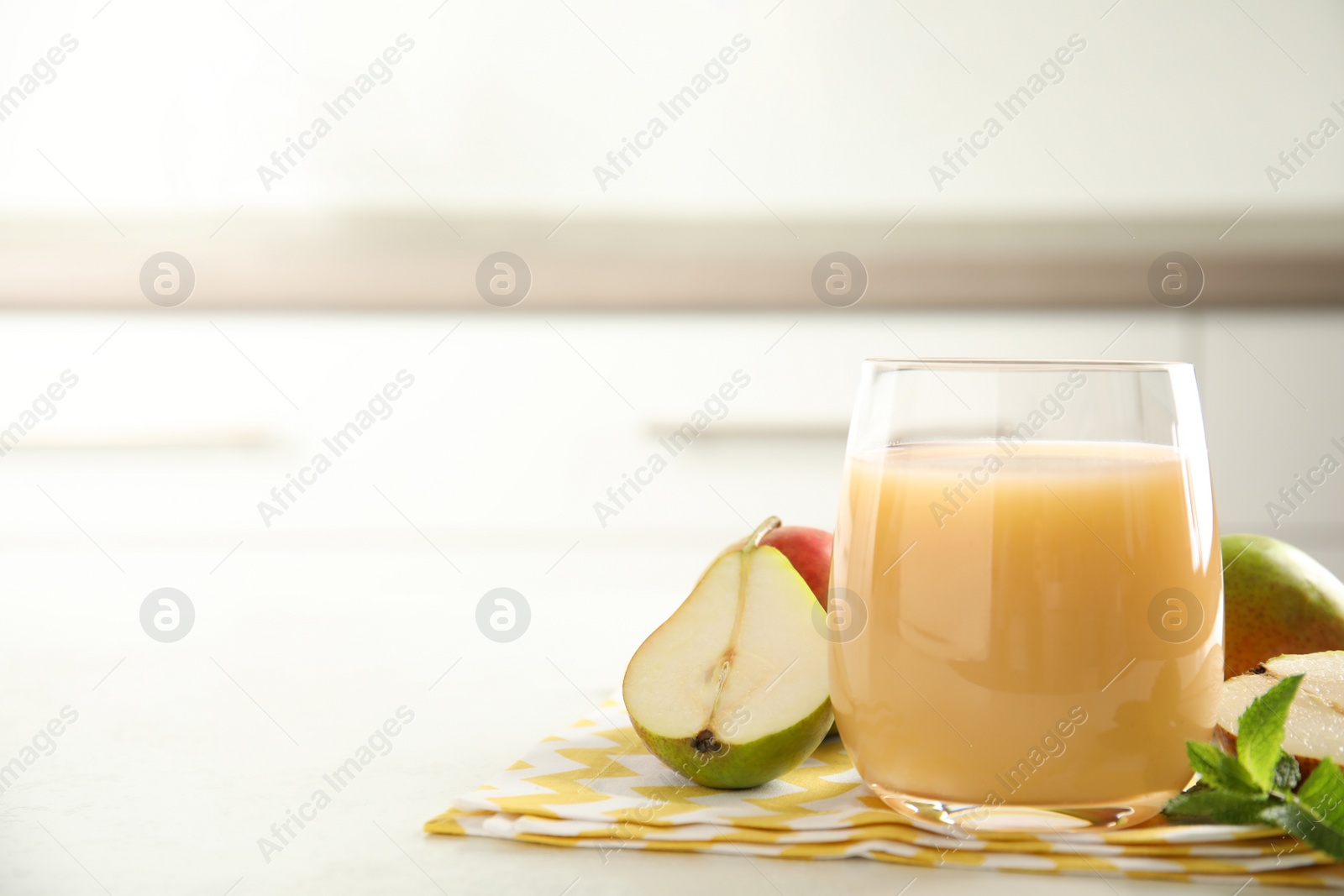 Photo of Tasty pear juice and cut fruit on white table, closeup. Space for text