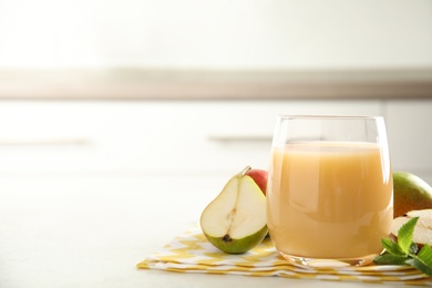 Tasty pear juice and cut fruit on white table, closeup. Space for text