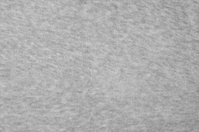 Light grey cloth with lint as background, top view. Before using fabric shaver