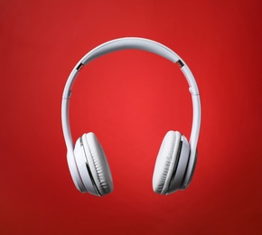 Photo of Stylish modern headphones with earmuffs on color background