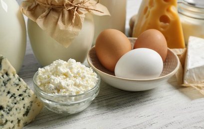 Photo of Different dairy products on white wooden table, closeup