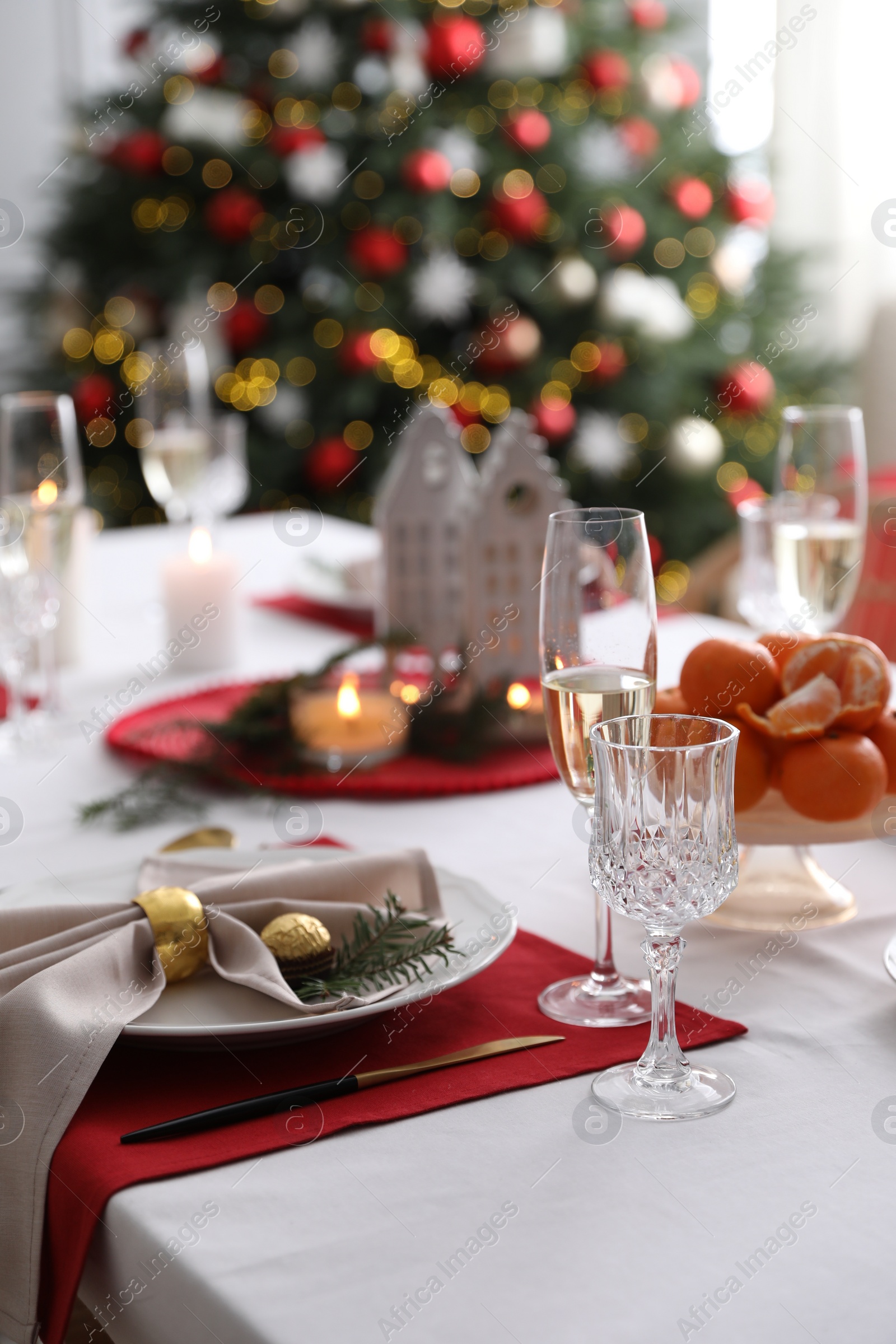 Photo of Christmas table setting with beautiful napkin, cutlery and dishware indoors