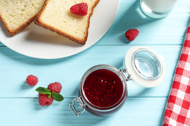 Image of Sweet raspberry jam and toasts for breakfast on turquoise wooden table, flat lay
