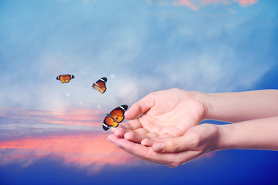 Image of Woman releasing butterflies on color background, closeup. Freedom concept