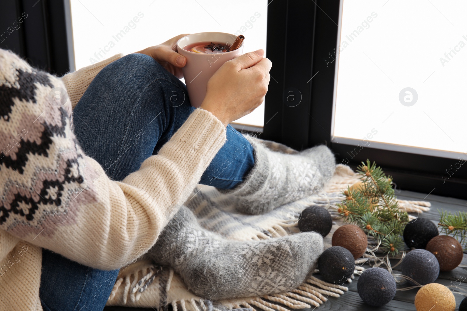 Photo of Woman relaxing with hot winter drink near window. Cozy season