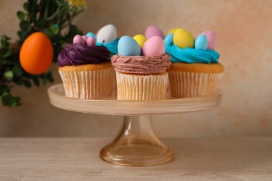 Photo of Tasty cupcakes with Easter decor on wooden table