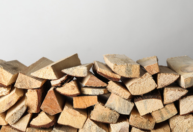 Photo of Cut firewood on light grey background. Heating in winter
