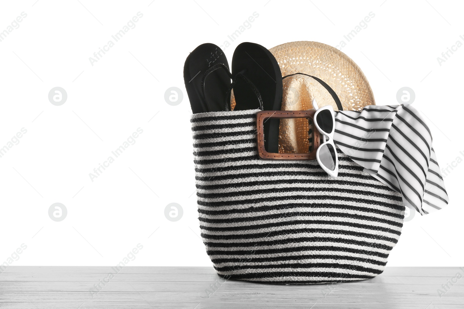 Photo of Set of beach accessories on wooden table, white background