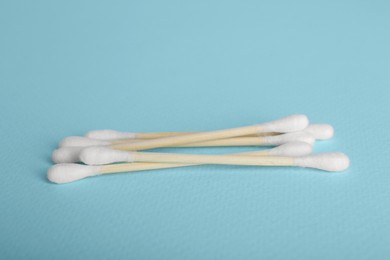 Wooden cotton buds on light blue background