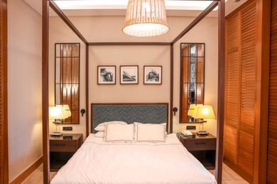 Photo of Large bed, lamps and pictures in comfortable hotel room
