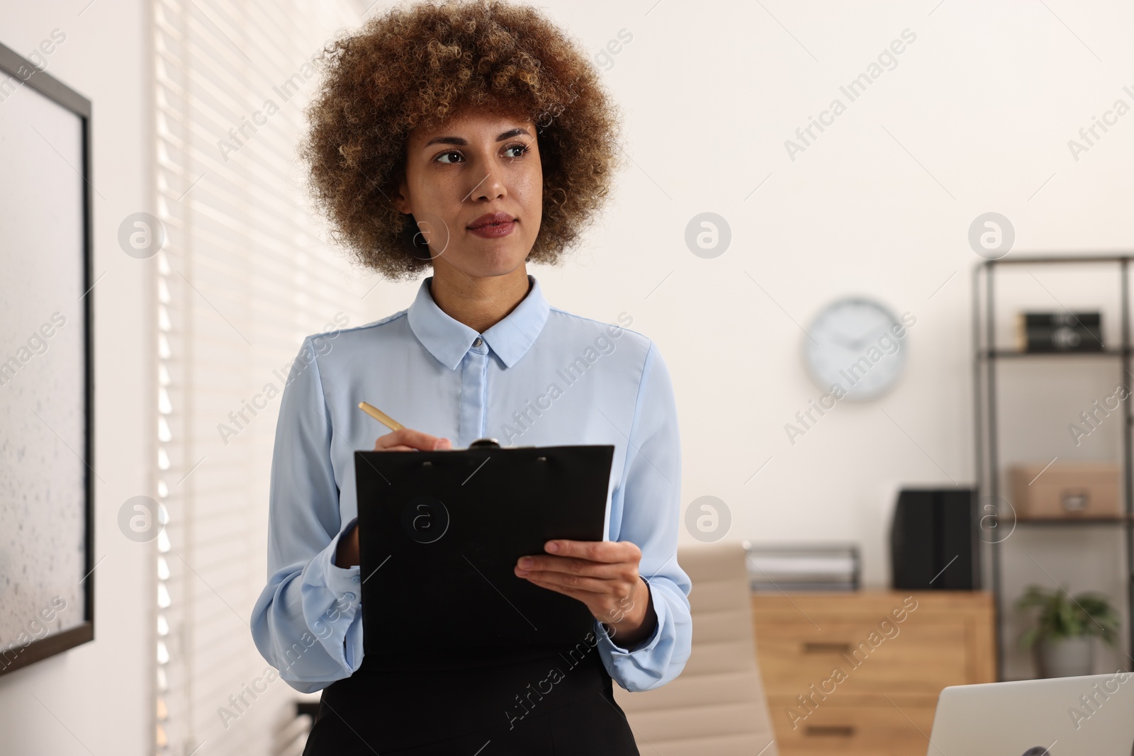 Photo of Notary with clipboard writing notes in office