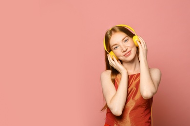 Photo of Portrait of beautiful young woman with headphones on pink background, space for text