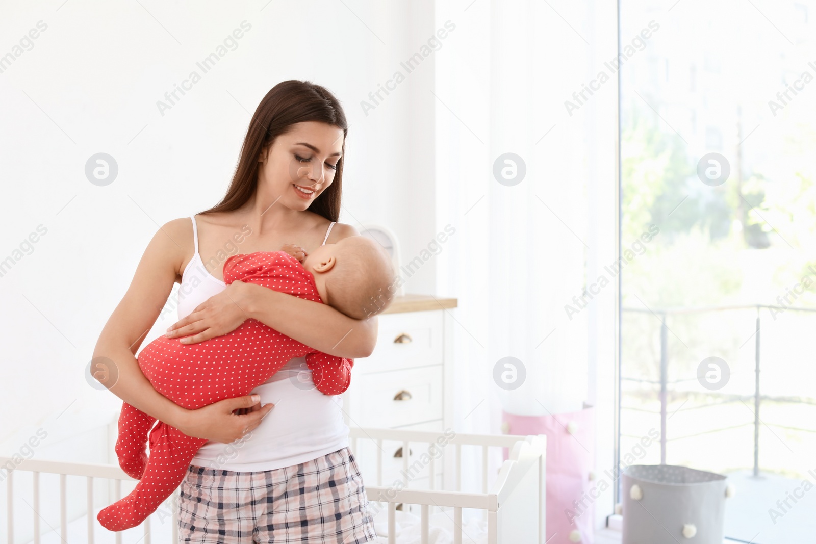 Photo of Young mother with her cute baby girl at home