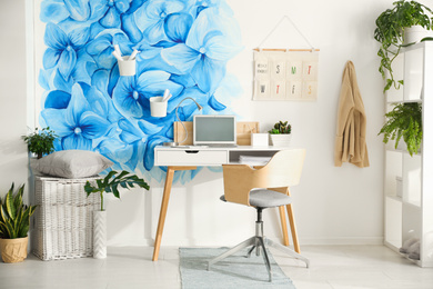 Photo of Stylish living room interior with blue flowers painted on wall. Floral pattern