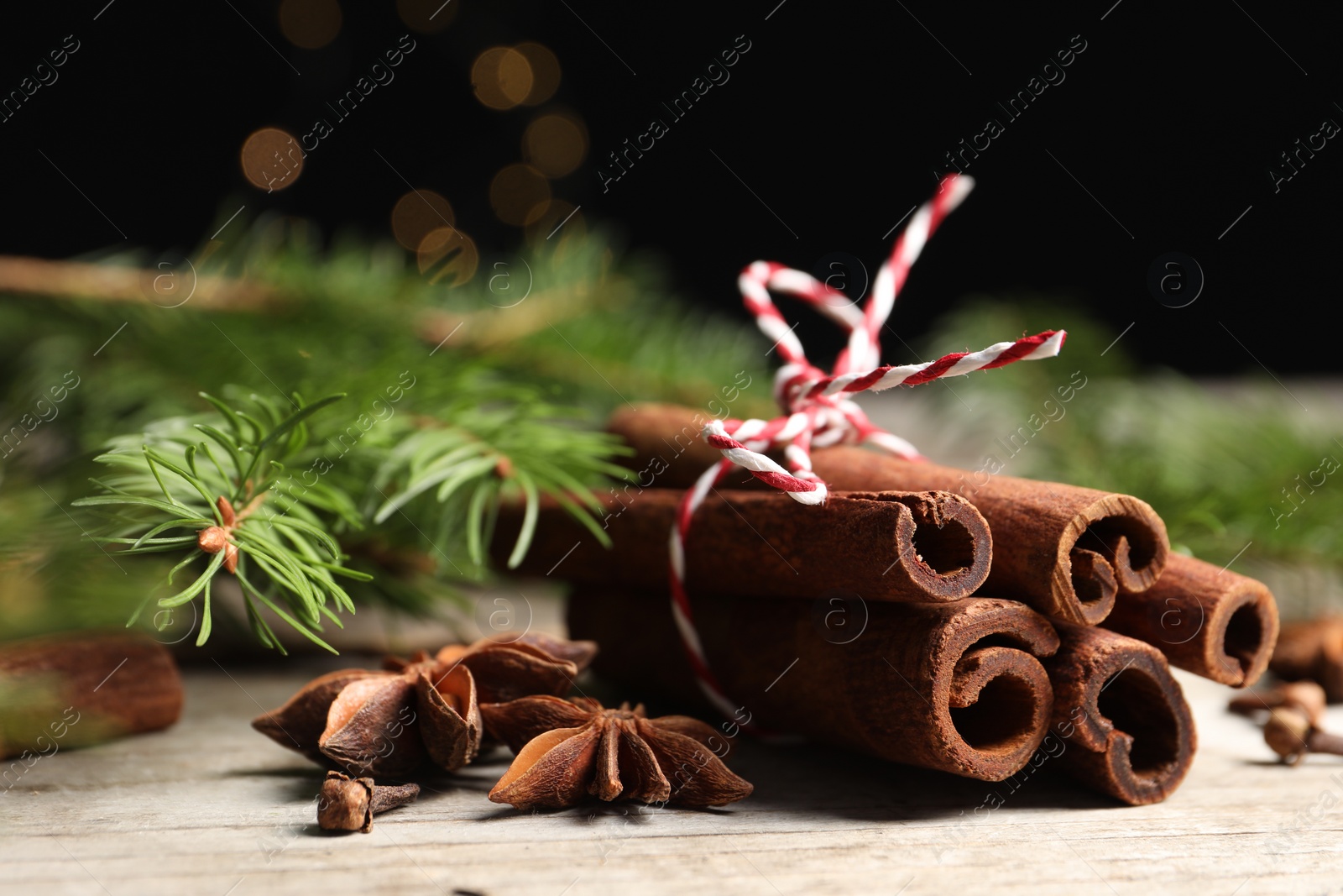 Photo of Different spices and fir branches on wooden table, closeup