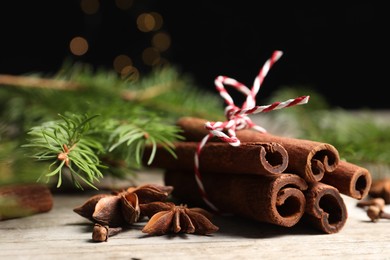 Different spices and fir branches on wooden table, closeup