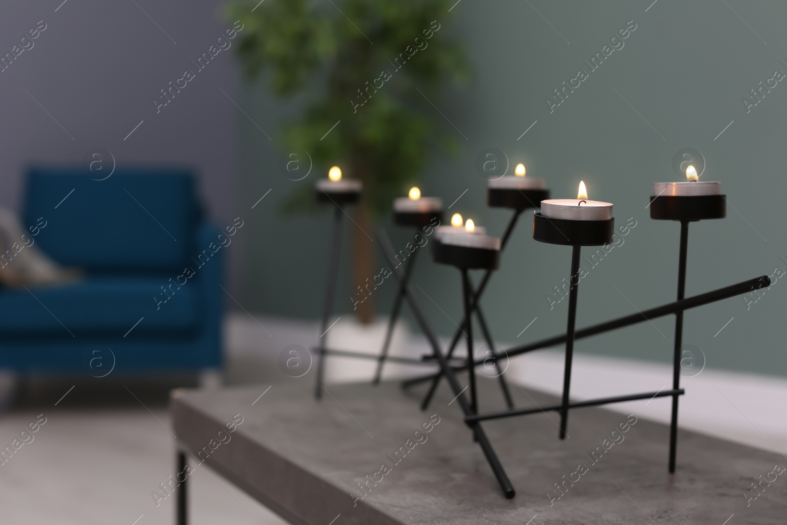 Photo of Burning candles on table indoors. Interior decor element