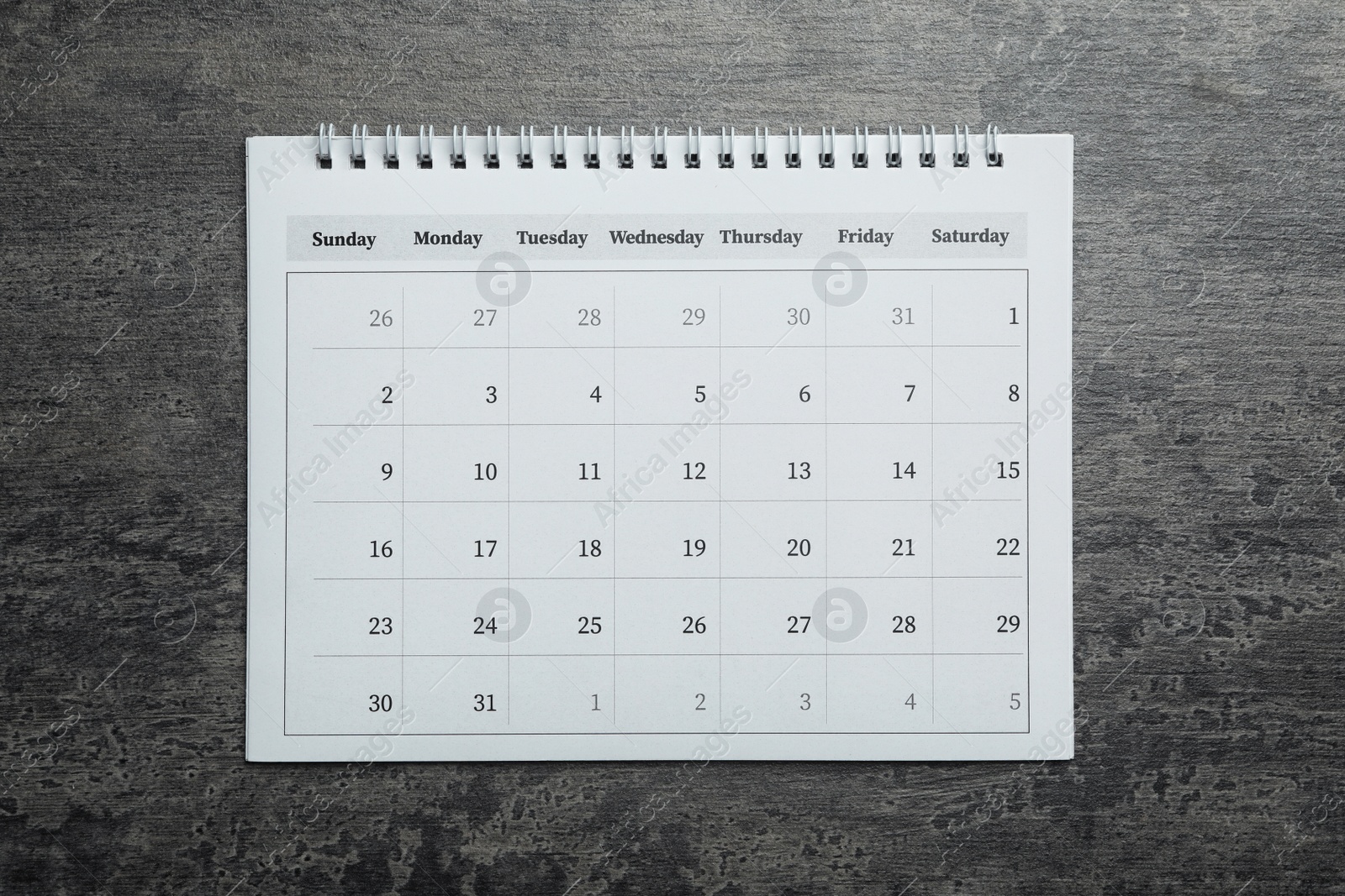 Photo of Paper calendar on grey stone background, top view