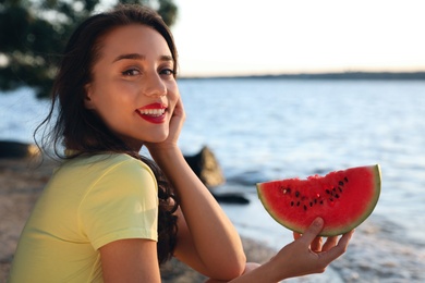 Photo of Beautiful young woman with watermelon near river