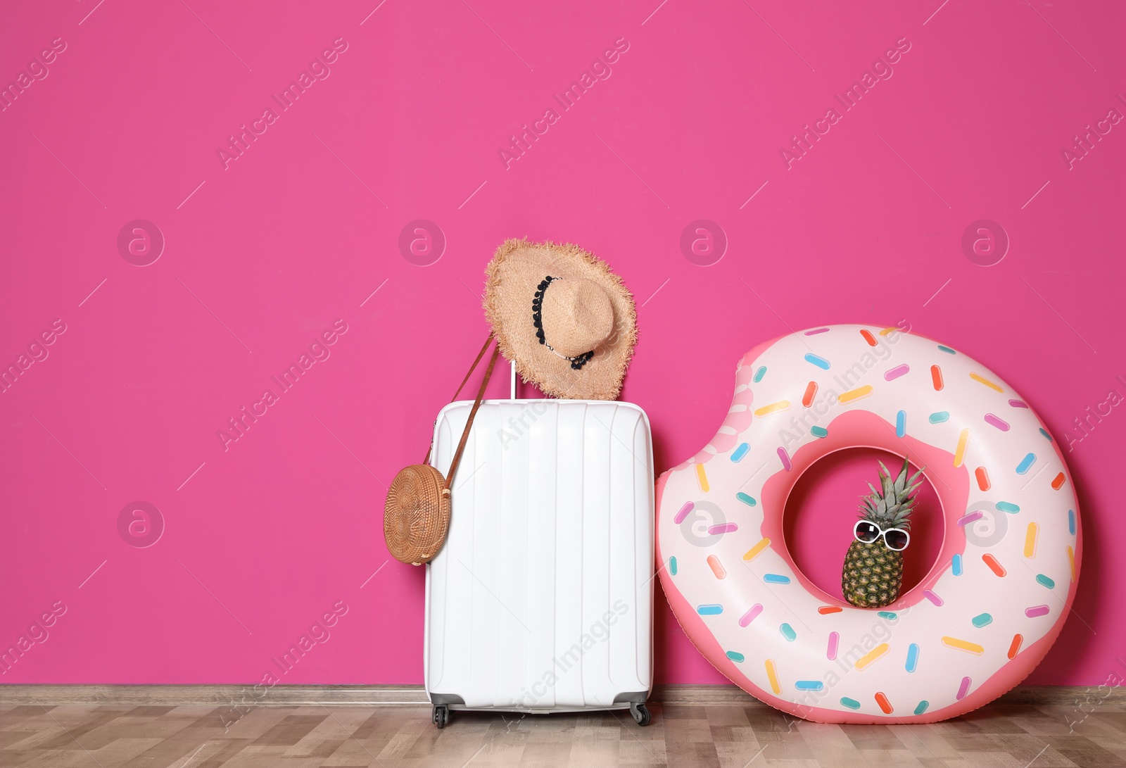 Photo of Large suitcase for travelling and beach items with space for text near color wall