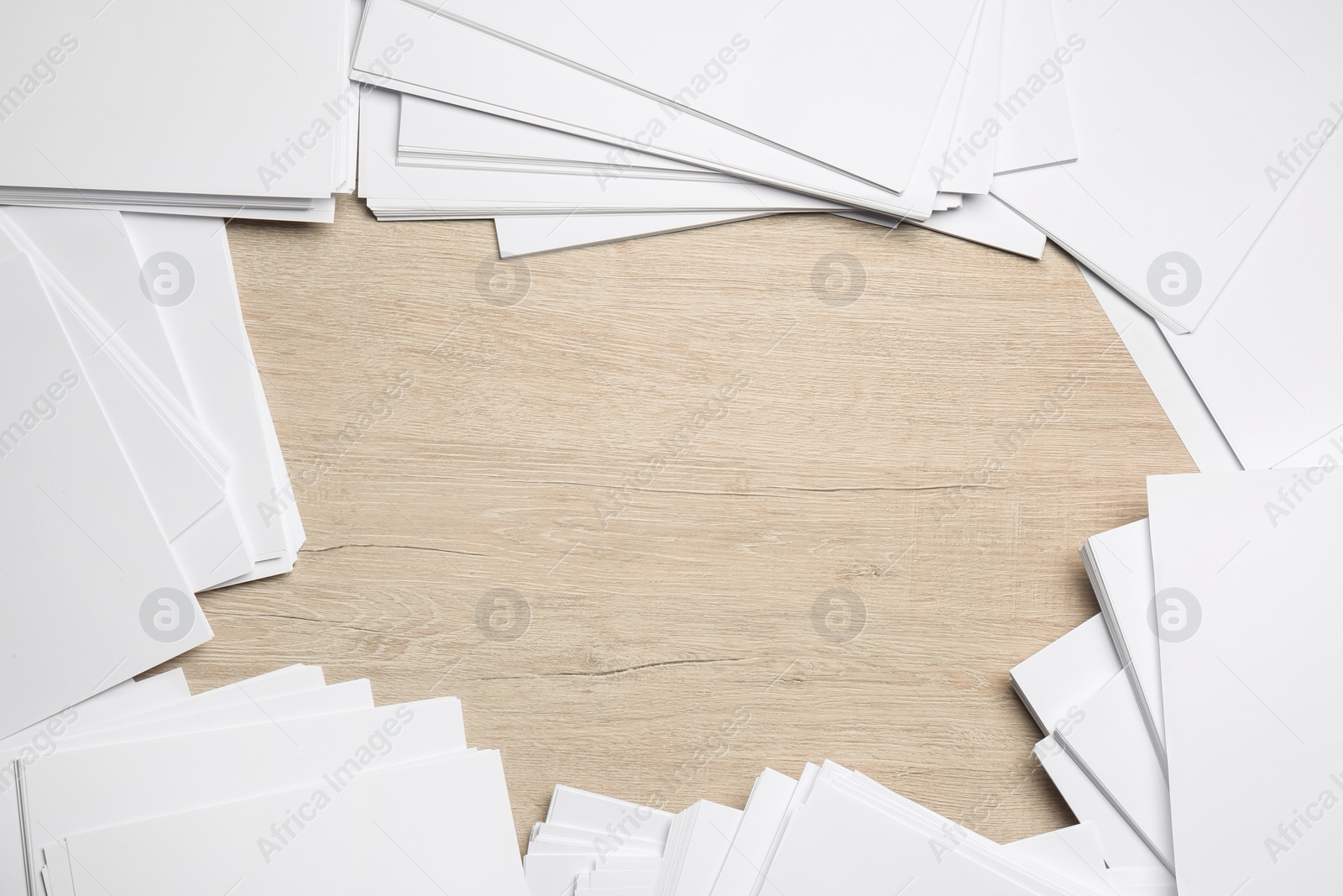 Photo of Frame of white paper sheets on wooden table, flat lay. Space for text