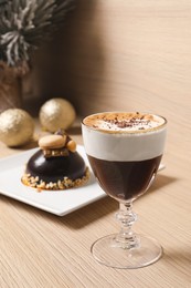 Photo of Aromatic coffee drink and delicious chocolate dessert on wooden table