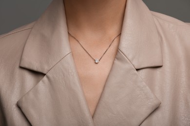 Photo of Woman with elegant necklace on dark grey background, closeup
