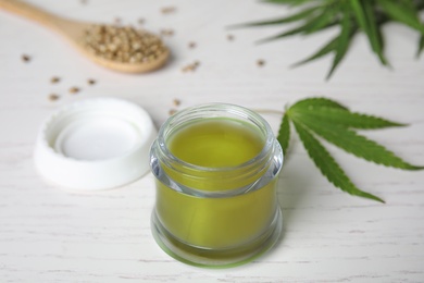 Photo of Jar of hemp cream on white wooden table. Organic cosmetics