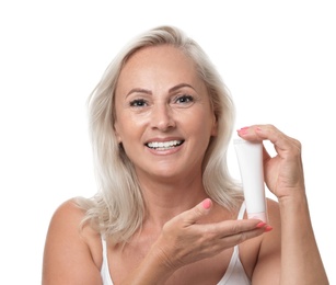 Portrait of beautiful mature woman with perfect skin holding tube of cream on white background