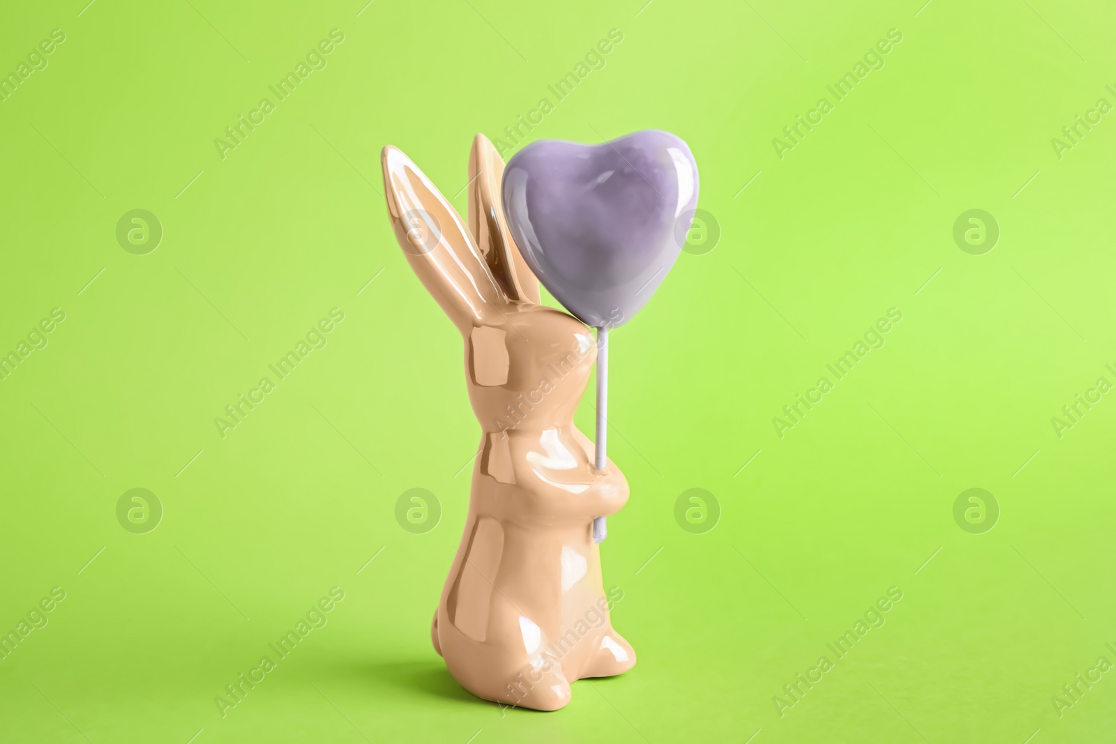 Photo of Bunny ceramic figure as Easter decor on green background