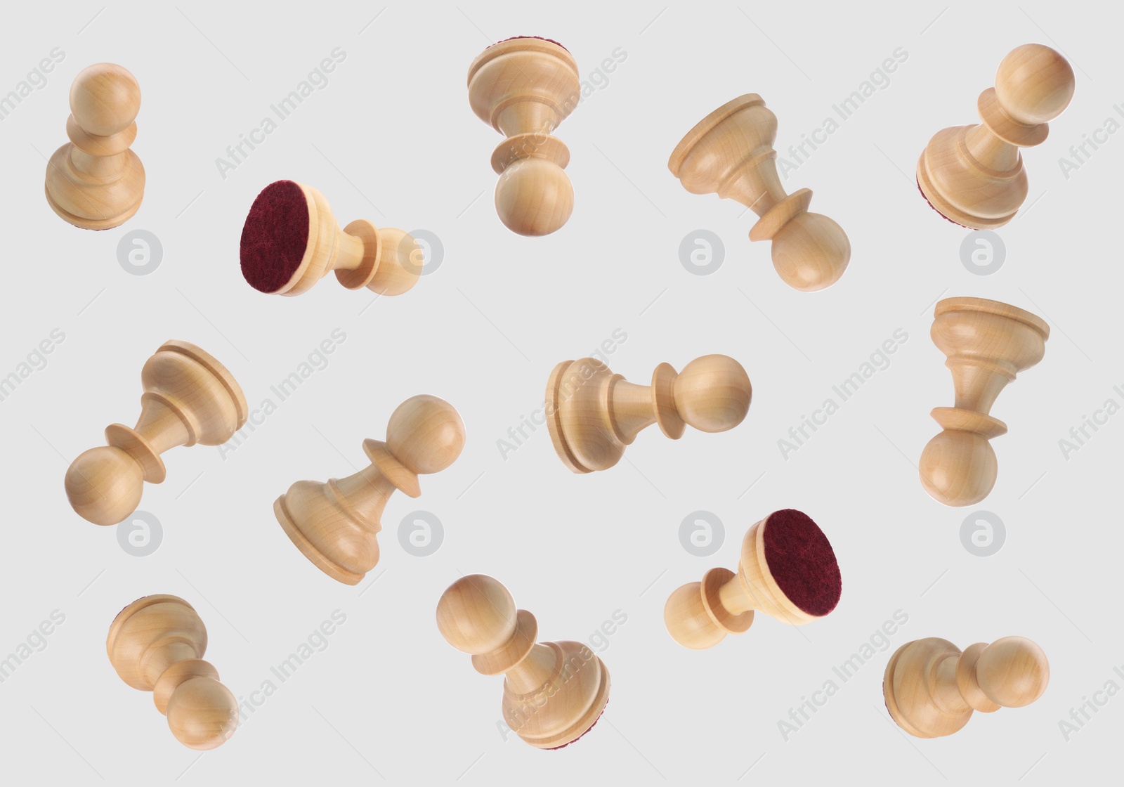 Image of Wooden chess pawns falling on light grey background