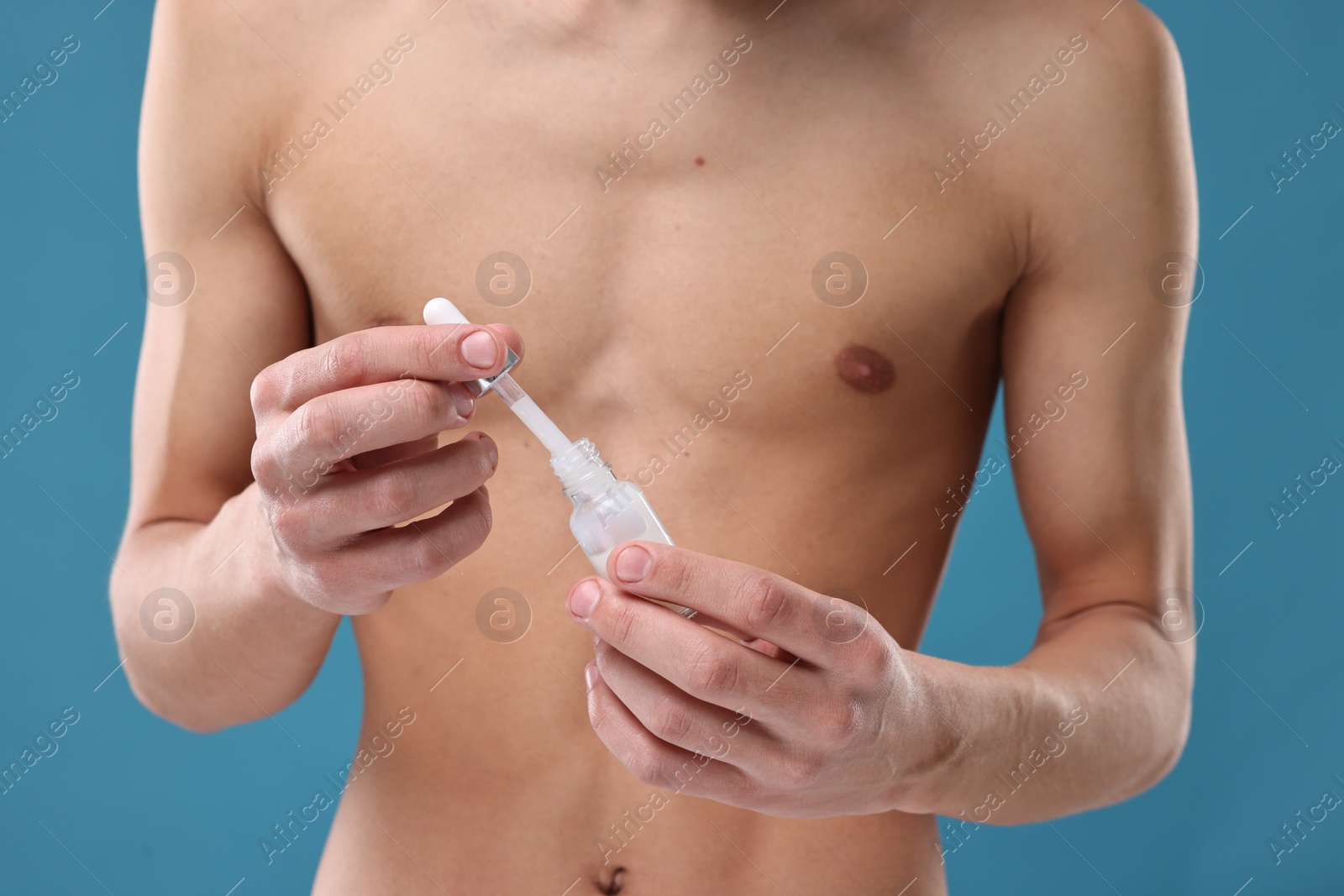 Photo of Man with serum on blue background, closeup