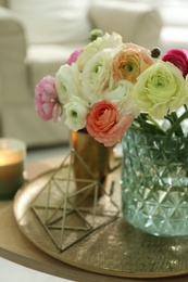 Photo of Beautiful ranunculus flowers in vase on wooden table indoors, closeup