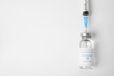 Photo of Filling syringe with coronavirus vaccine on white  background, flat lay. Space for text