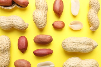 Fresh peanuts on yellow background, flat lay