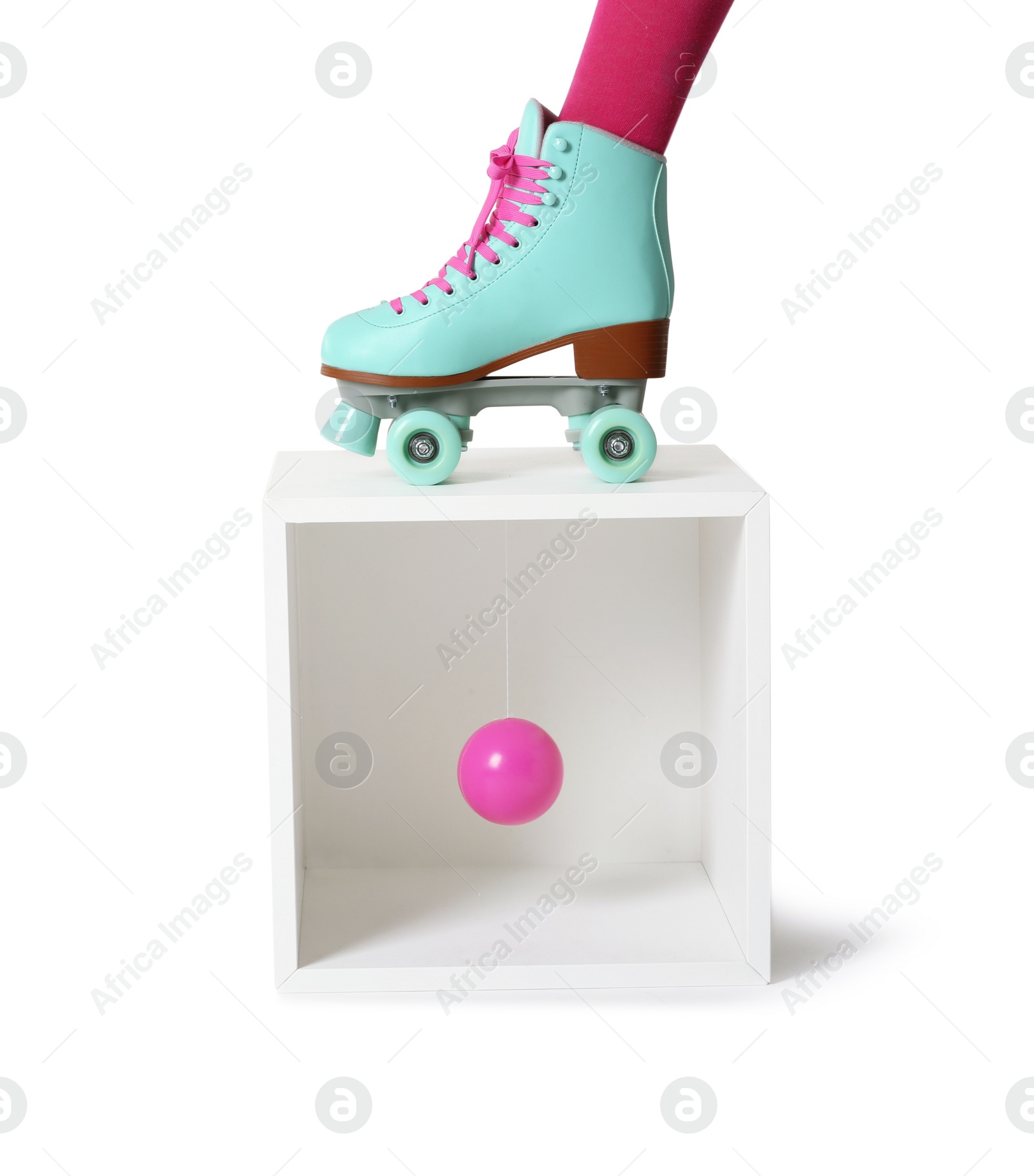 Photo of Woman wearing vintage roller skate and storage cube with ball on white background, closeup