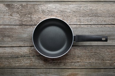 Photo of New non-stick frying pan on wooden table, top view