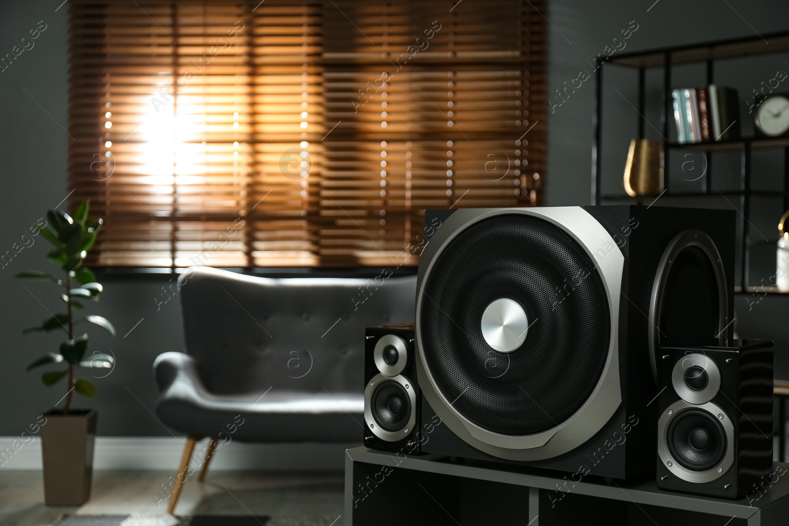 Photo of Modern audio speaker system on wooden table in living room