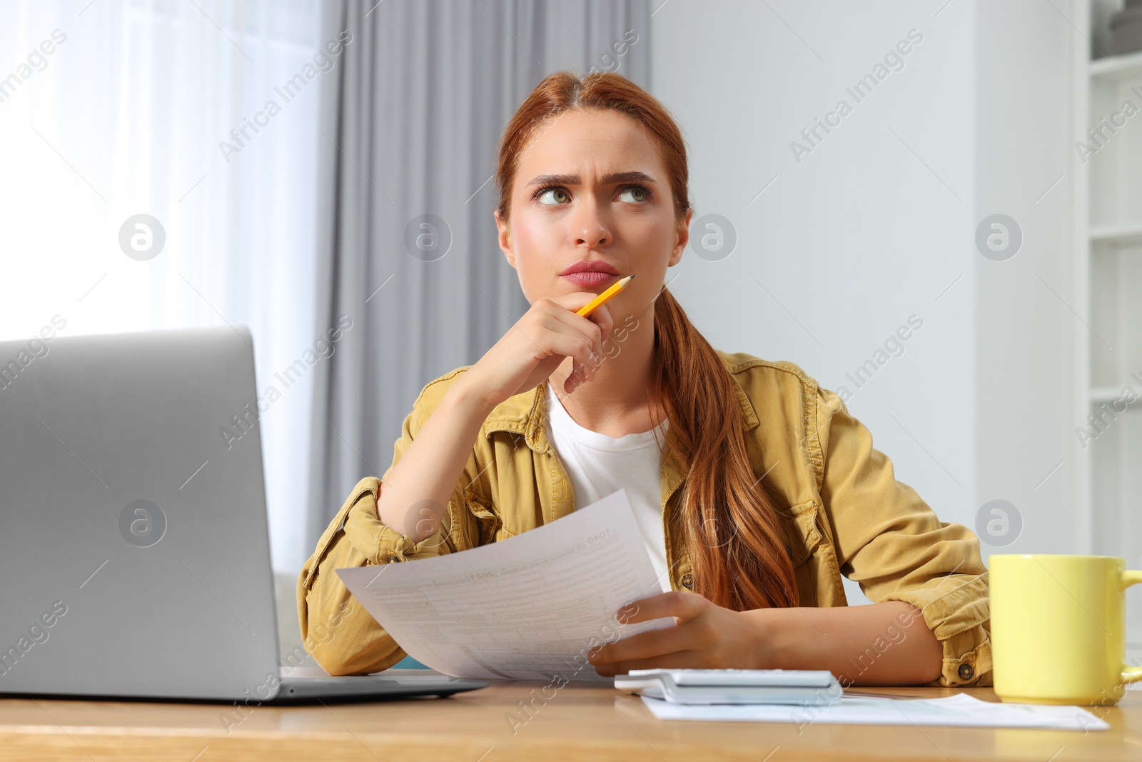 Photo of Woman doing taxes at table in room