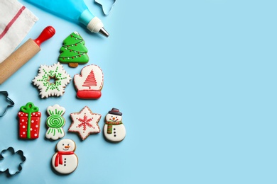 Photo of Flat lay composition with delicious gingerbread cookies and kitchen items on light blue background. Space for text