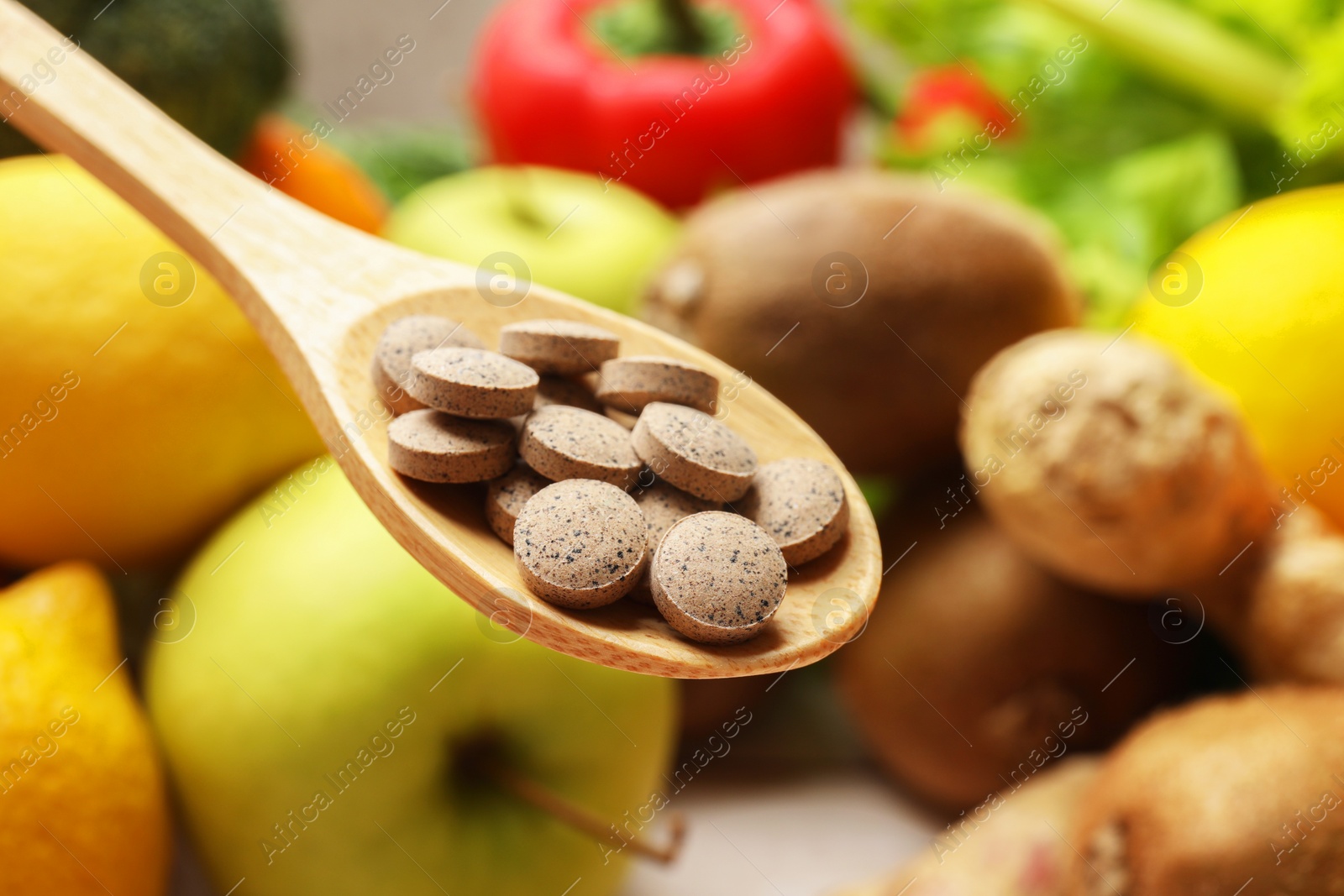 Photo of Dietary supplements. Spoon with pills over food products, closeup