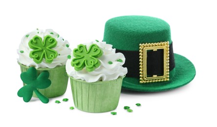 Photo of St. Patrick's day party. Tasty festively decorated cupcakes and green leprechaun hat, isolated on white