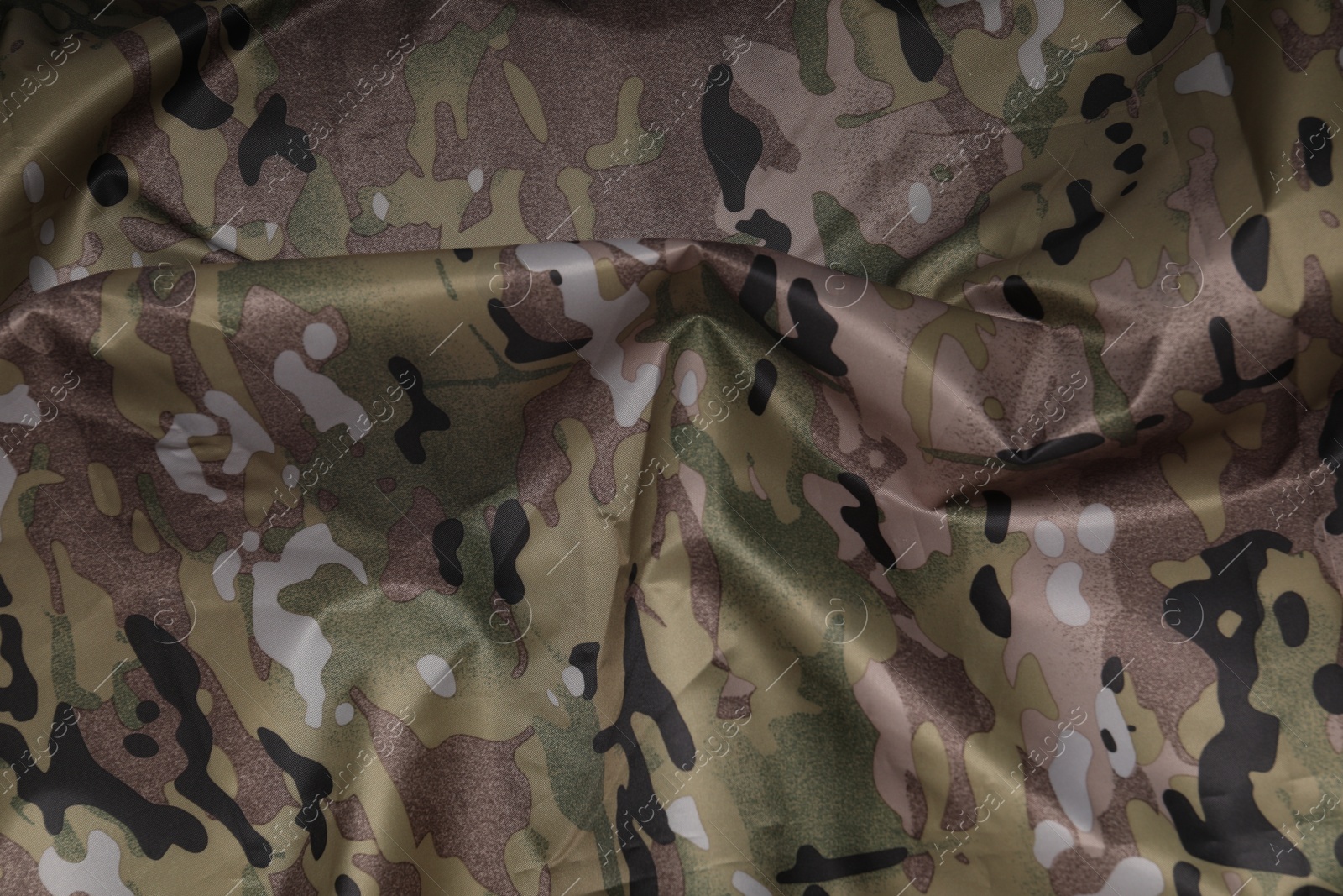 Photo of Texture of crumpled camouflage fabric as background, top view