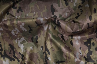 Texture of crumpled camouflage fabric as background, top view