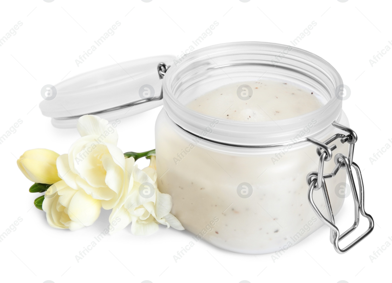 Photo of Jar of exfoliating salt scrub and freesia flowers on white background