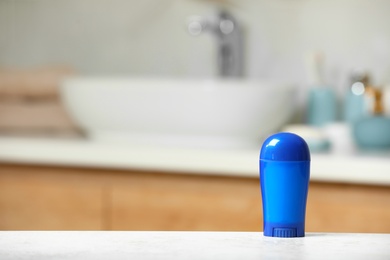 Photo of Stick deodorant on table in bathroom, space for text