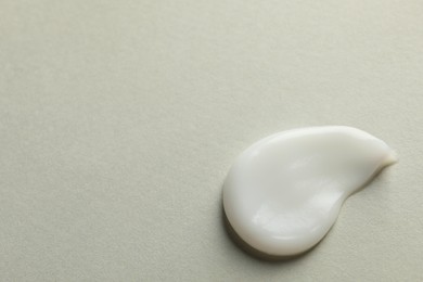 Photo of Sample of face cream on light background, top view. Space for text