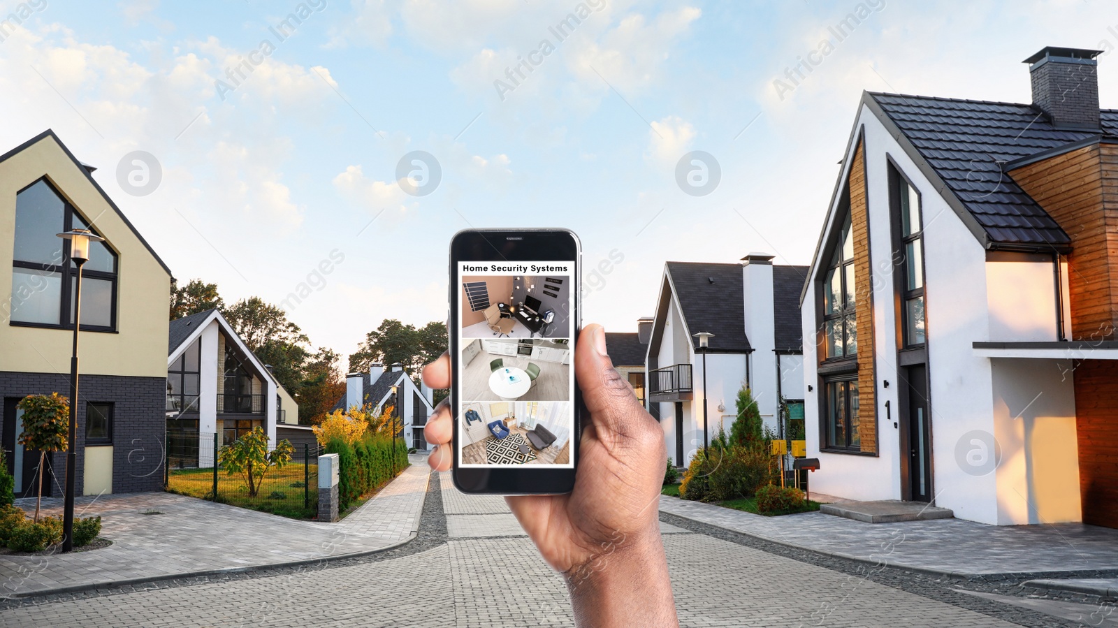 Image of Alarm system. African-American man monitoring modern CCTV cameras on smartphone outdoors, closeup