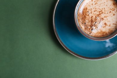 Cup of aromatic hot coffee on color background, top view